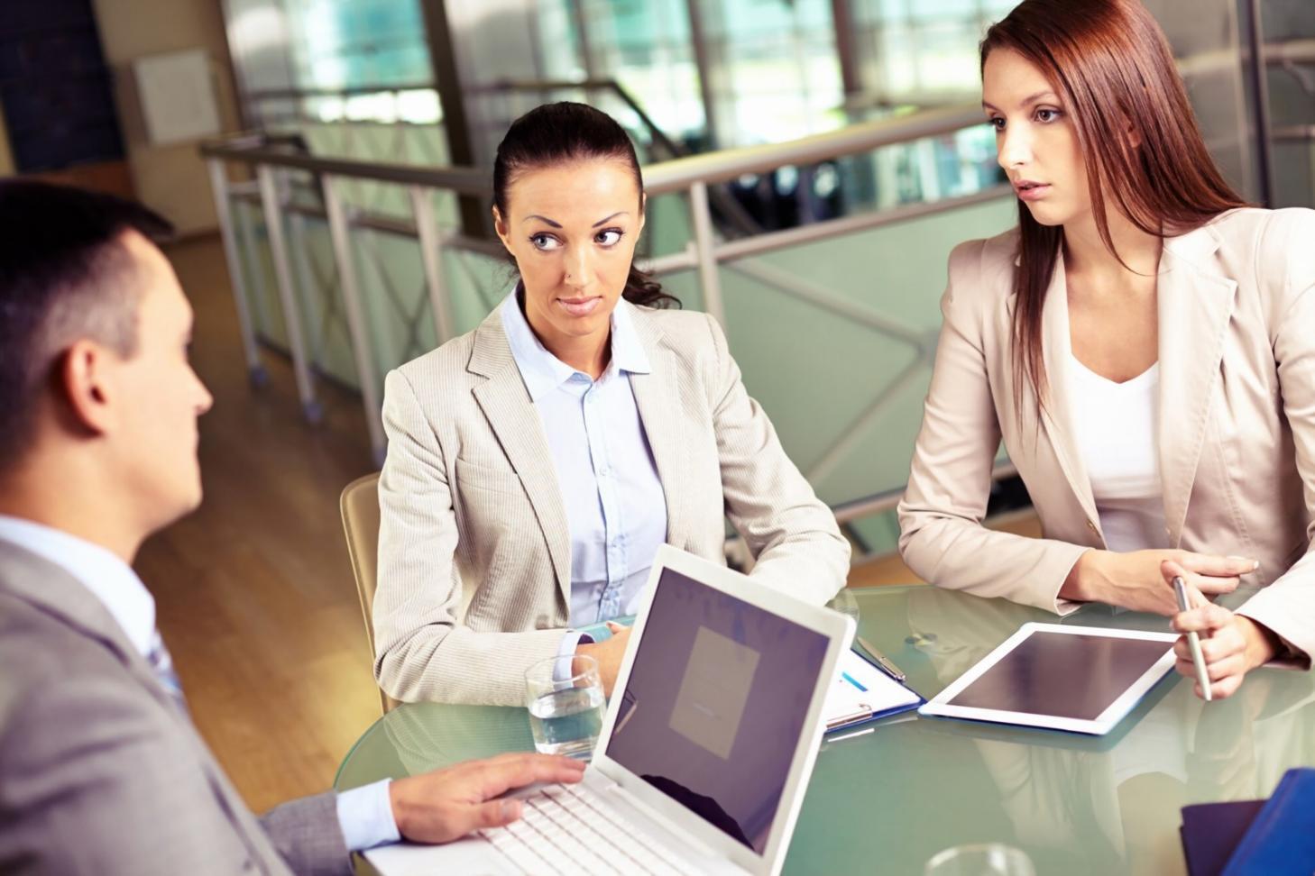 Business professionals collaborating over financial documents and benchmarking analysis